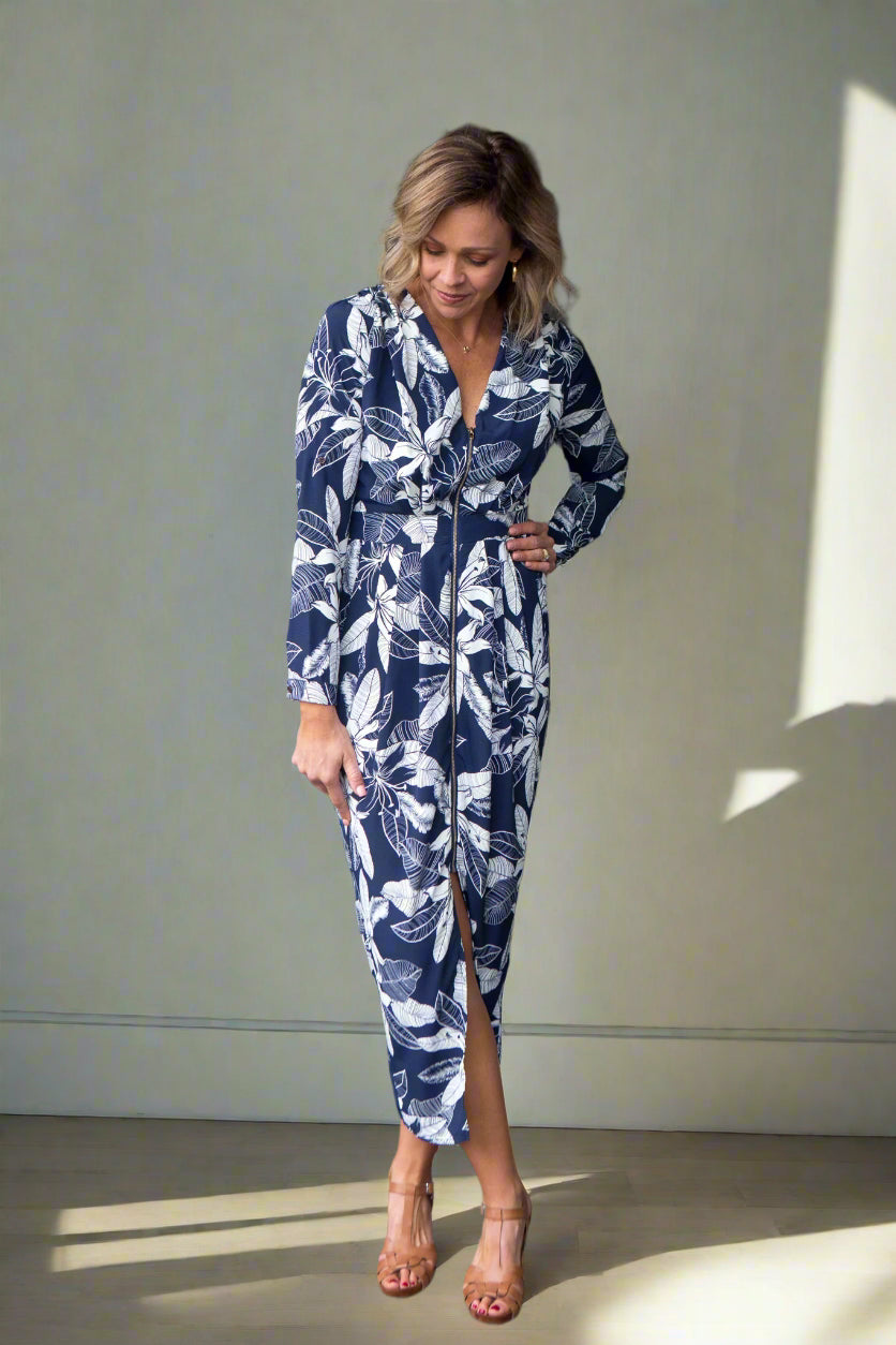 Woman wearing a blue and white patterned dress standing indoors